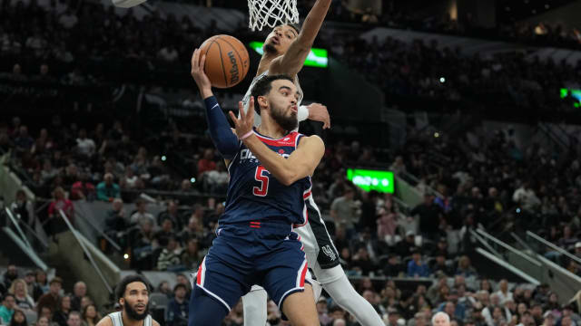 Washington Wizards guard Tyus Jones (5) looks to pass under the arm of San Antonio Spurs center Victor Wembanyama (1) in the second half at Frost Bank Center in San Antonio on Jan. 29, 2024.
